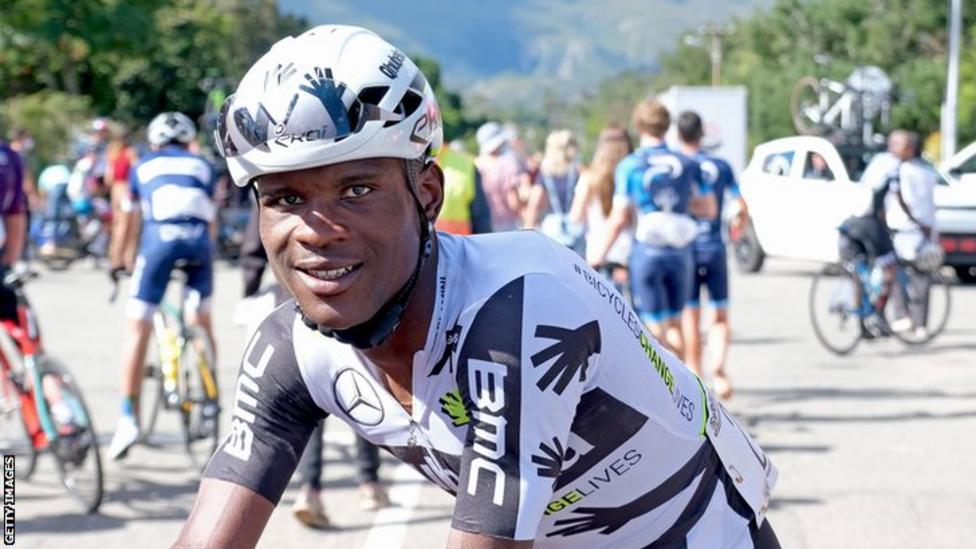 A closeup photo of a bicycle rider smiling at the camera