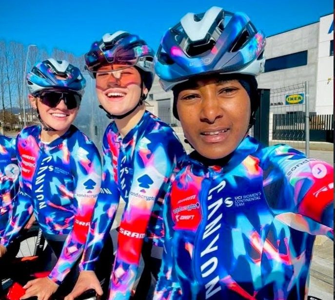 Three cyclists in colorful gear ready to ride outdoors.
